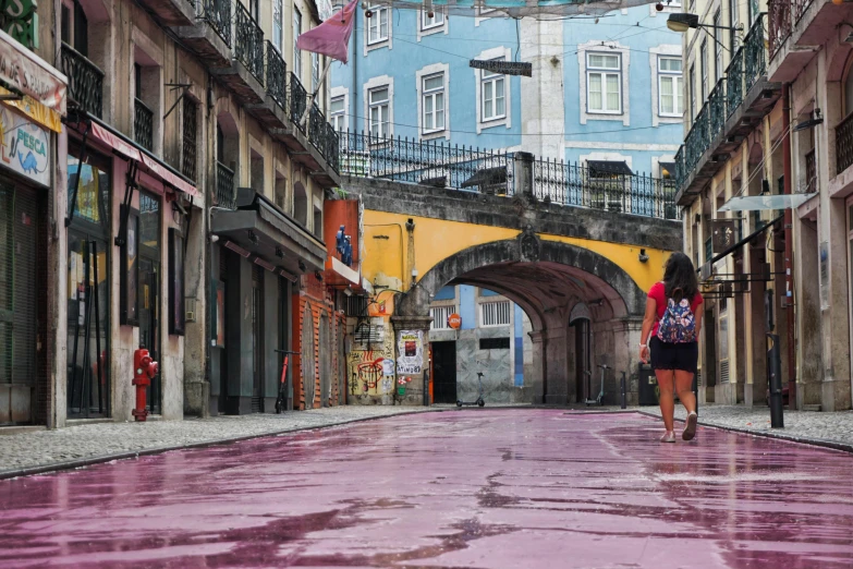 a woman walking down a wet street with an umbrella, by david rubín, pexels contest winner, graffiti, pink marble building, ponte 2 5 de abril, square, unfinished