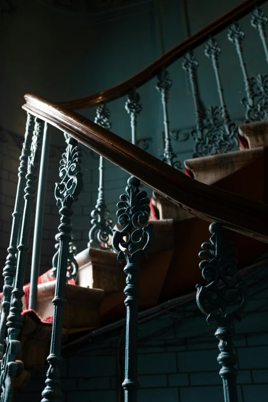 a close up of a staircase in a building, inspired by Joseph Wright of Derby, baroque, muted blue and red tones, wunderkammer, iron railing, copper and deep teal mood