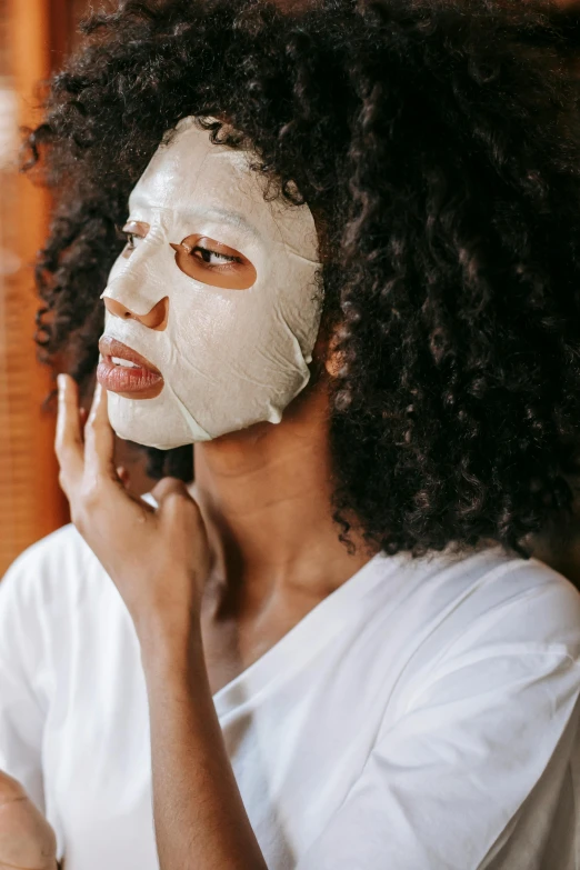 a woman with a sheet mask on her face, trending on pexels, portrait of ororo munroe, botanicals, woman with black hair, with textured hair and skin