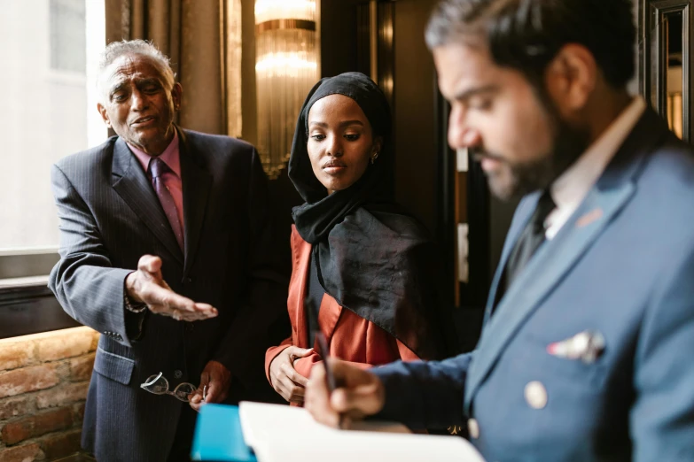 a group of people standing next to each other, by Joseph Severn, pexels contest winner, hurufiyya, standing at the resolute desk, imaan hammam, dialogue, subject detail: wearing a suit