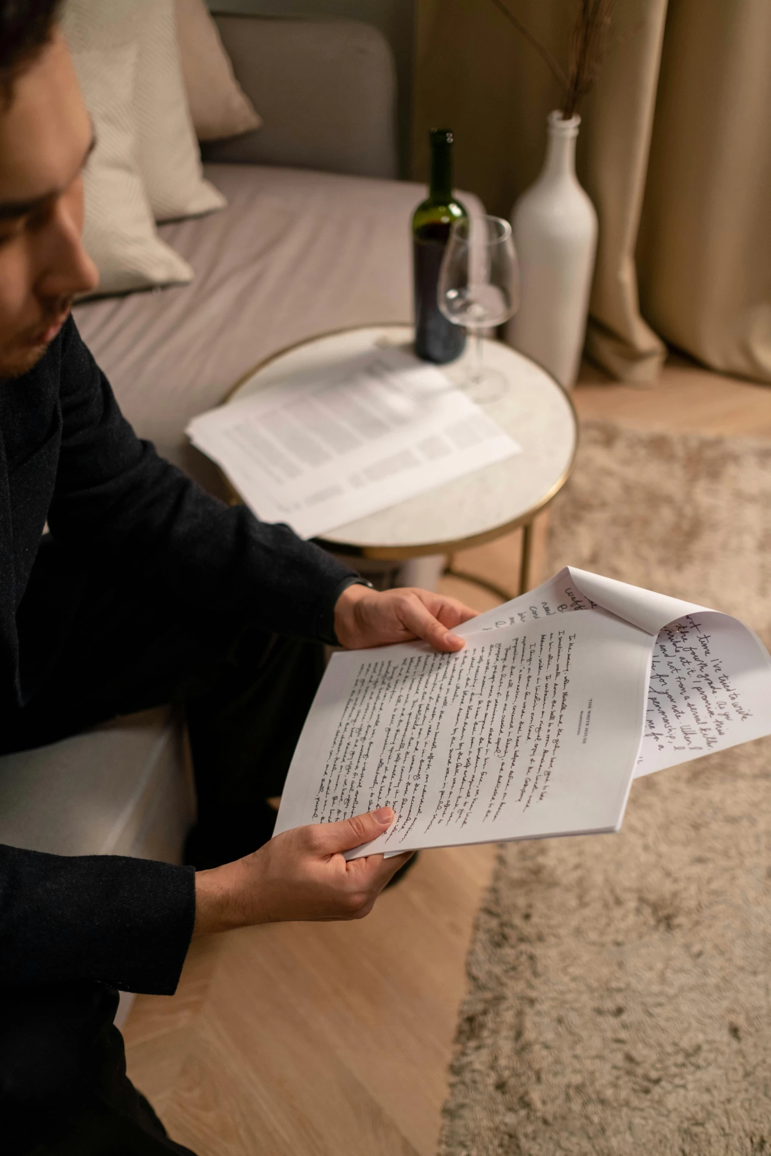 a man sitting on a couch reading a paper, by Julia Pishtar, pexels contest winner, with some hand written letters, ignant, sebastian ludke, on vellum