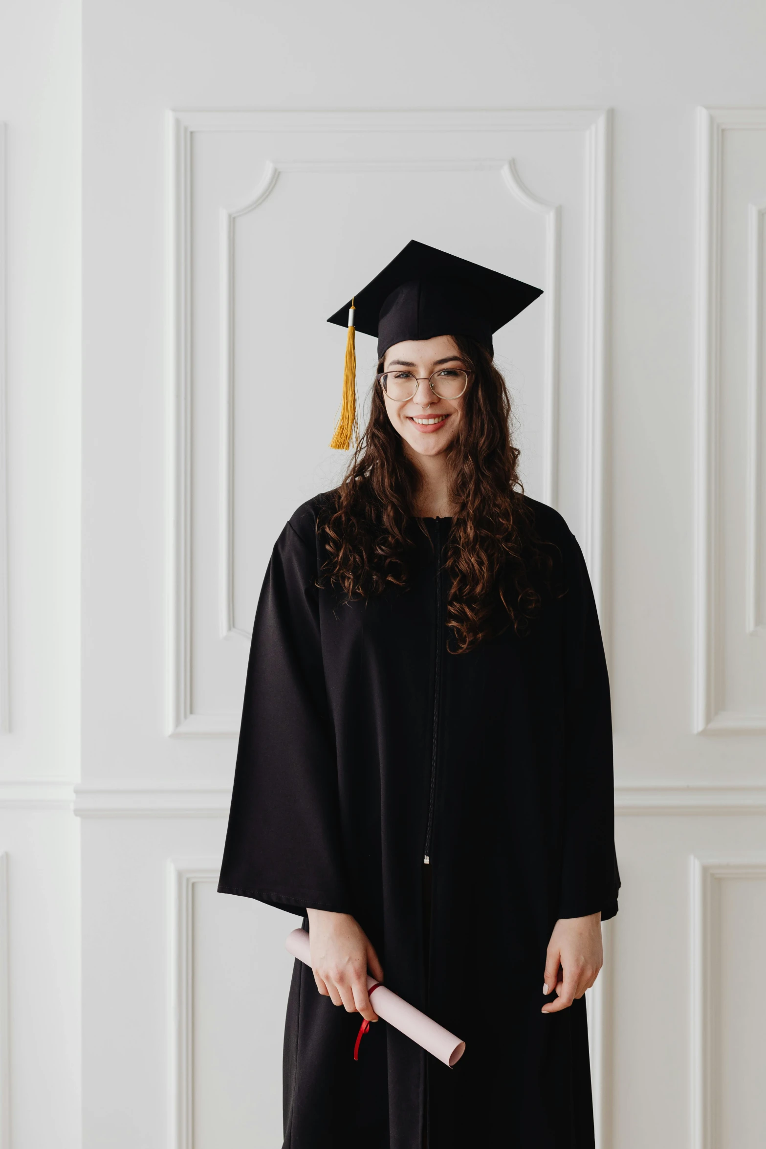 a woman in a graduation gown holding a diploma, a portrait, pexels, academic art, wearing black clothes and cape, portrait n - 9, standing in corner of room, young woman with long dark hair