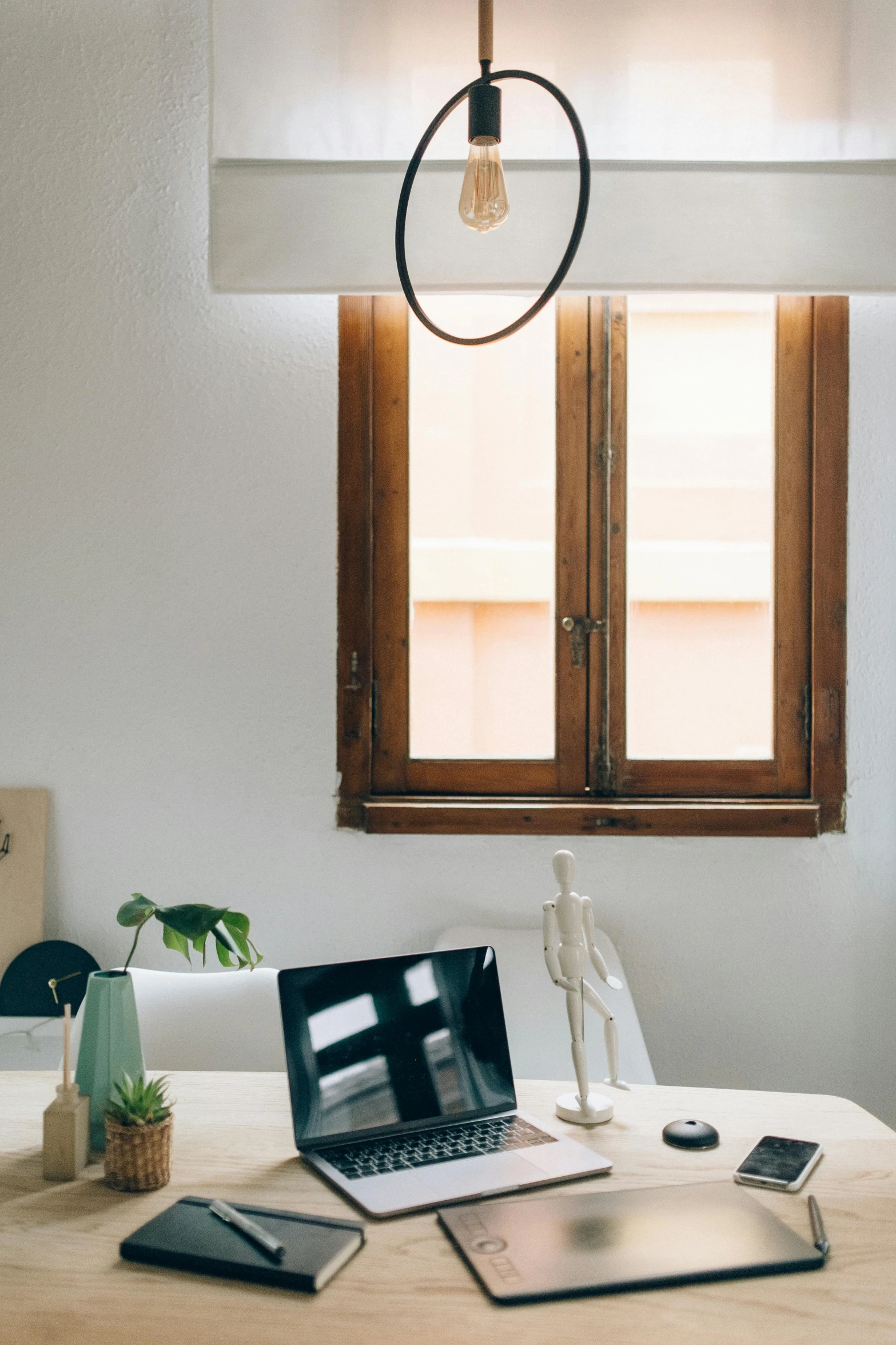 a laptop computer sitting on top of a wooden table, by Évariste Vital Luminais, light and space, light fixtures, centered wide framed window, curated collections, professional comercial vibe