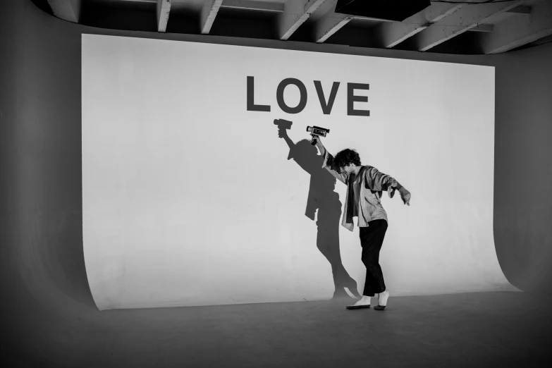 a couple of people that are standing in front of a wall, a black and white photo, by Miroslava Sviridova, unsplash, graffiti, alec soth : : love, live performance, robert sheehan, shadow