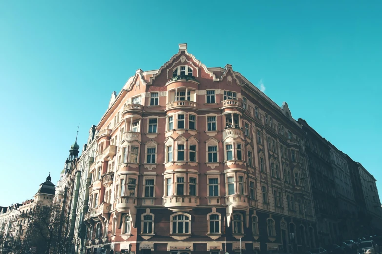 a tall building sitting on the side of a street, by Emma Andijewska, pexels contest winner, art nouveau, sunny day time, retro style ”, square, huge mansion