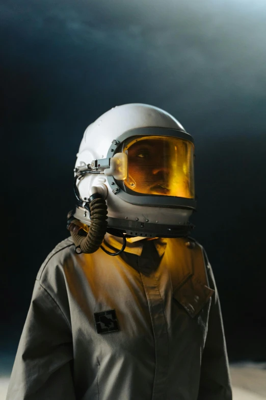 a person wearing a space suit and a helmet, a colorized photo, pexels contest winner, low key, white uniform, yellow helmet, military pilot clothing