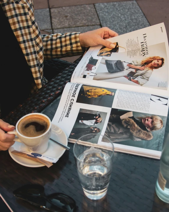 a person sitting at a table with a cup of coffee, clippings of a fashion magazine, two cups of coffee, thumbnail, hassleblad