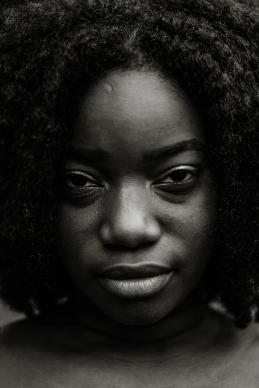 a black and white photo of a woman with curly hair, by Chinwe Chukwuogo-Roy, pexels contest winner, hyperrealism, skeptical expression, black teenage girl, grainy photo of an ugly woman, closeup portrait