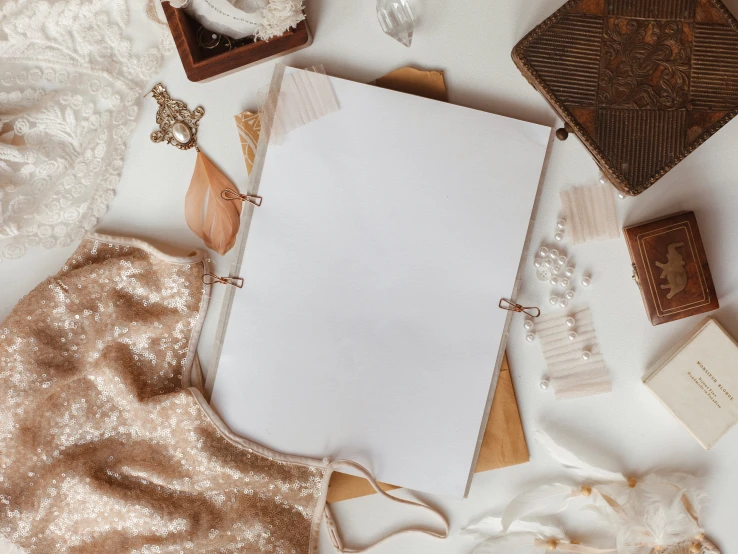 a white sheet of paper sitting on top of a table, a picture, trending on pexels, white and gold dress, flatlay book collection, background image, brown and white color scheme