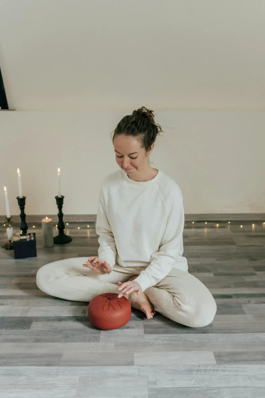 a woman sitting on the floor with a red ball, natural candle lighting, kundalini energy, hammershøi, profile image