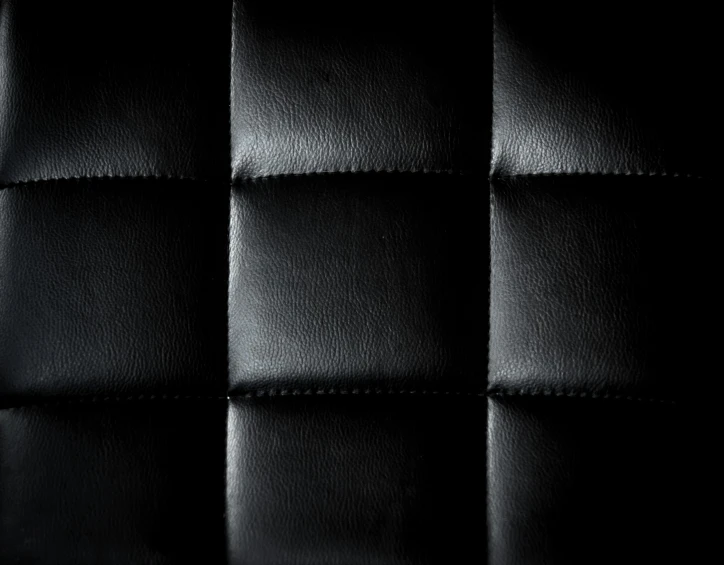 a close up of a black leather seat, inspired by Pierre Soulages, trending on pexels, squares, leather padding, textured 3 d, panel of black