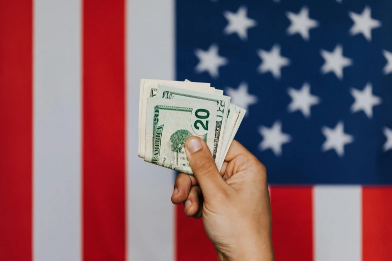 a person holding a stack of money in front of an american flag, pexels contest winner, 🎀 🗡 🍓 🧚, instagram post, usa-sep 20, flat