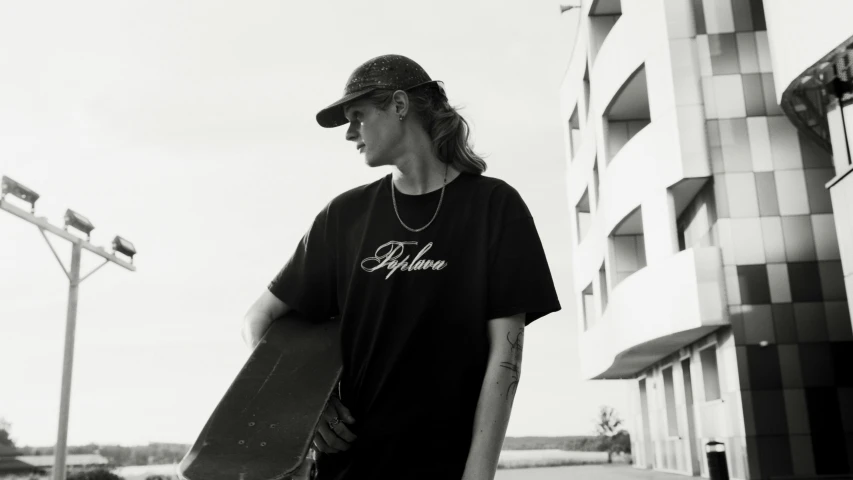 a black and white photo of a man holding a skateboard, black t shirt, albion, jovana rikalo, official store photo