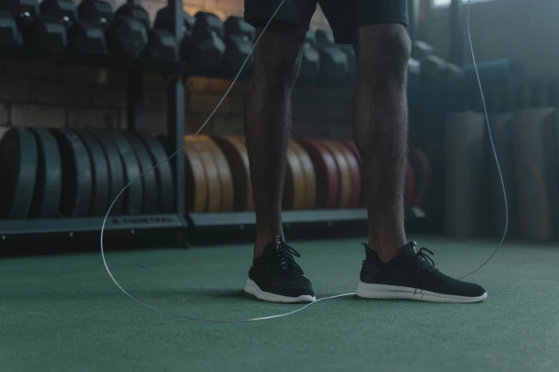 a man using a jump rope in a gym, pexels contest winner, black wired cables, cinematic rendered, zoomed out shot, inspect in inventory image