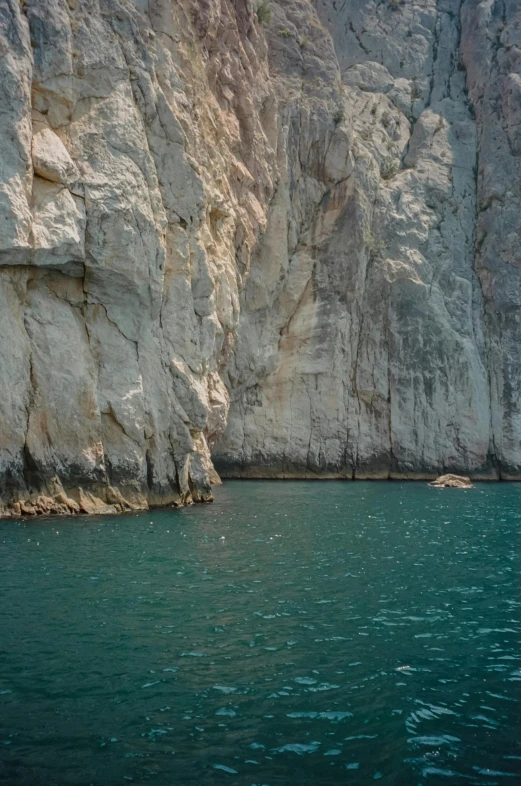 a large body of water next to a cliff, a picture, inspired by Elsa Bleda, romanticism, 2019 trending photo, oman, limestone, color”