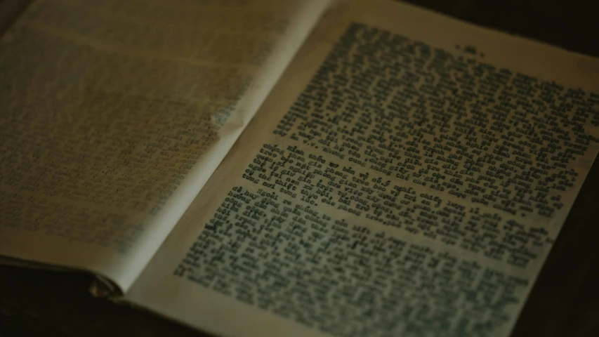 an open book sitting on top of a table, hebrew, documentary still, intricate writing, up close image