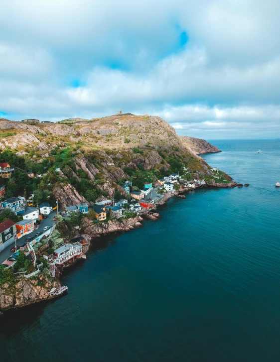 a large body of water next to a lush green hillside, a photo, by Kyle Lambert, pexels contest winner, art nouveau, small port village, maple syrup sea, archipelago, multicoloured