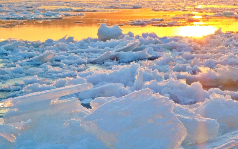 a bunch of ice floating on top of a body of water, at sunset, an award winning, plows, winter vibrancy