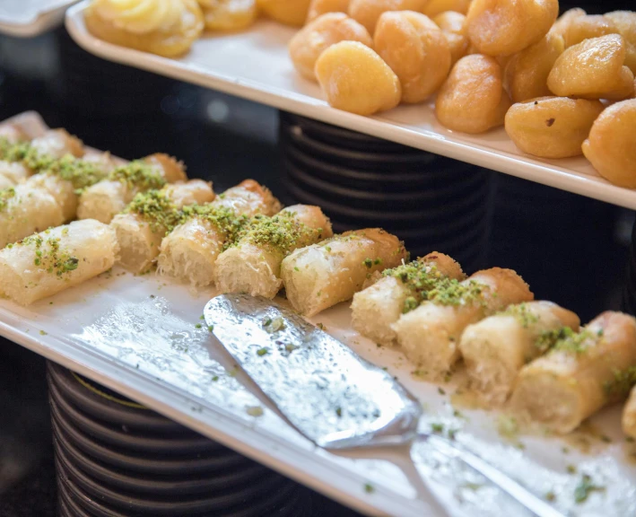 a bunch of trays of food sitting on top of a table, hurufiyya, sweets, medium detail, fan favorite, exterior shot