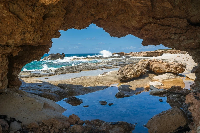 a view of the ocean through a hole in a rock, by Simon Marmion, pexels contest winner, renaissance, 4k panoramic, australian beach, ultra 4k, cyprus