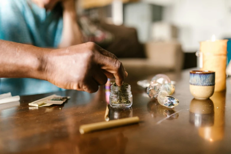 a close up of a person putting something in a jar, stoned, raytrayced, at home, sage smoke