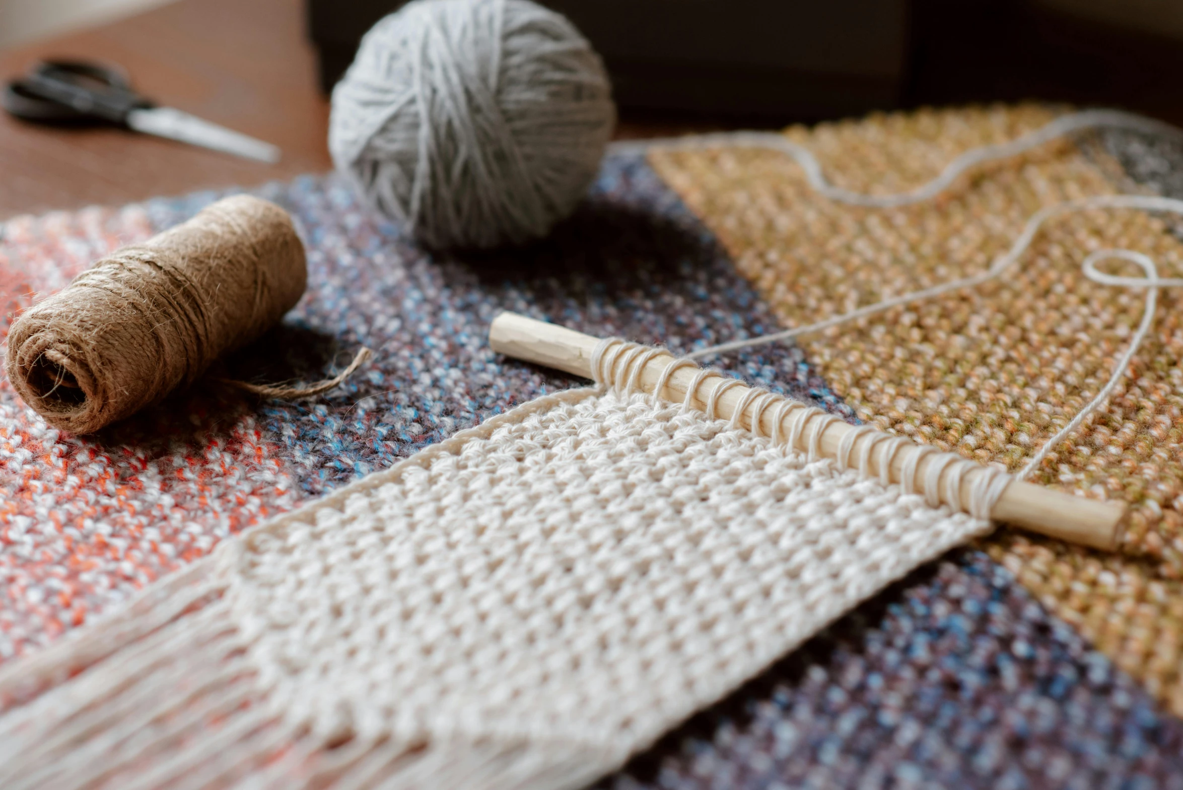 a pair of scissors sitting on top of a table, a portrait, inspired by Toss Woollaston, trending on pexels, arts and crafts movement, fibres trial on the floor, holding a wooden staff, weave, tweed colour scheme