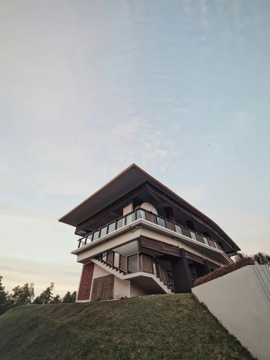 a tall building sitting on top of a lush green hillside, an album cover, inspired by Tadao Ando, unsplash, renaissance, peaceful wooden mansion, thai architecture, 😭 🤮 💕 🎀, modern house