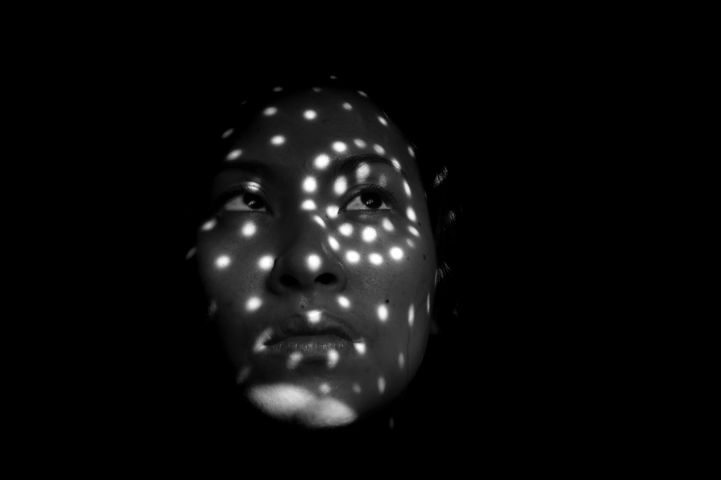 a black and white photo of a woman's face, inspired by Yayou Kusama, light and space, light show, chinese woman, shadow play, leds