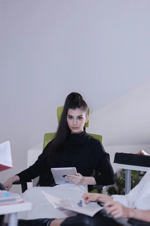 a group of people sitting around a table, girl in a suit