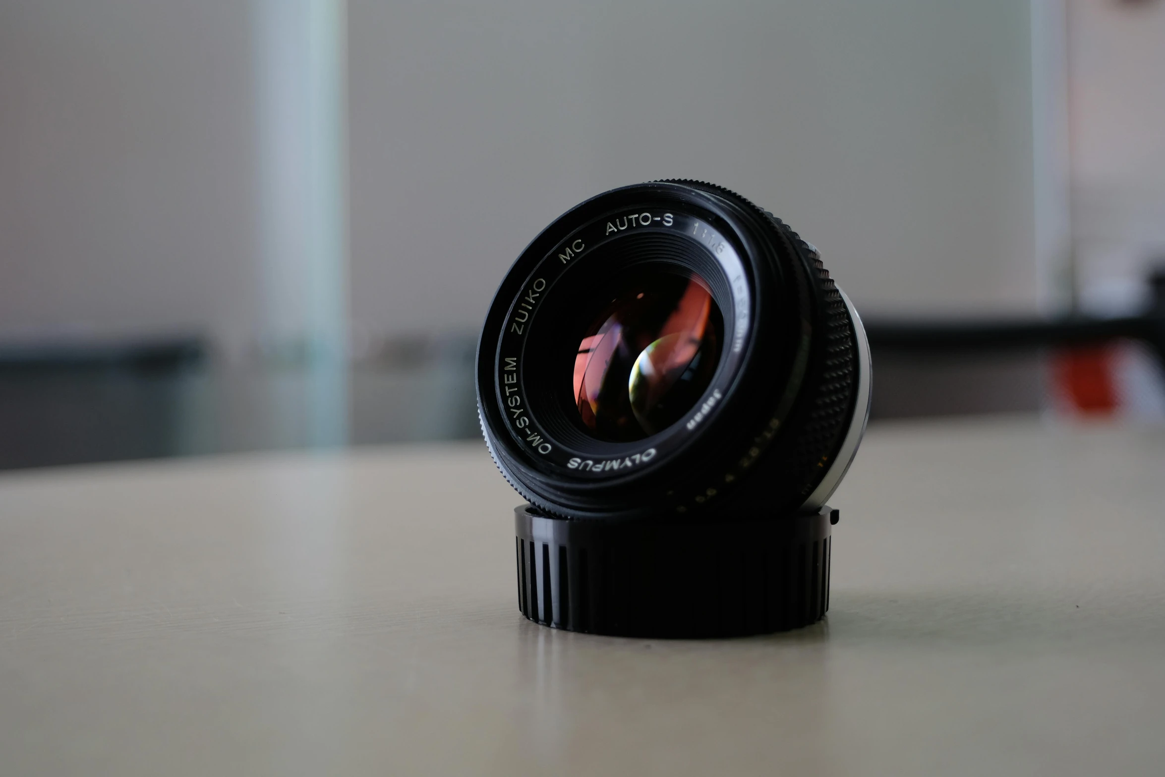 a close up of a camera lens on a table, by Mathias Kollros, unsplash, photorealism, medium format. soft light, panasonic 35mm, 4 5 mm. photorealistic, photorealistic 35mm'