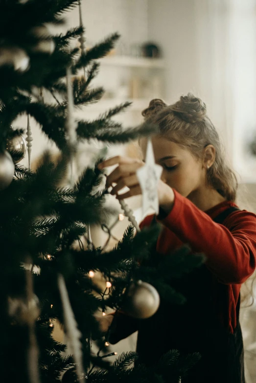 a little girl decorating a christmas tree, pexels contest winner, 1 6 years old, profile image, tissue ornament, handsome girl