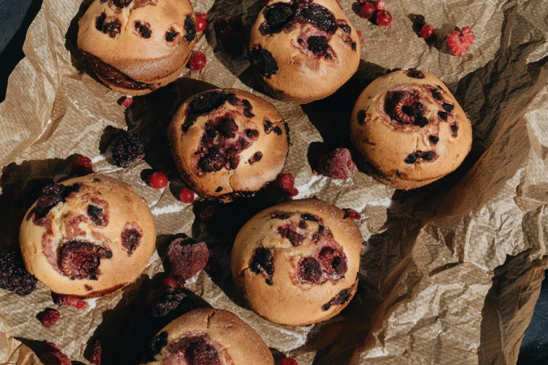 a bunch of muffins sitting on top of a piece of paper, trending on pexels, hurufiyya, berries inside structure, high quality product image”, background image, kacper niepokolczycki