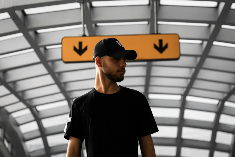 a man in a black shirt and a black hat, pexels contest winner, black. airports, avatar image, album cover, low - level view