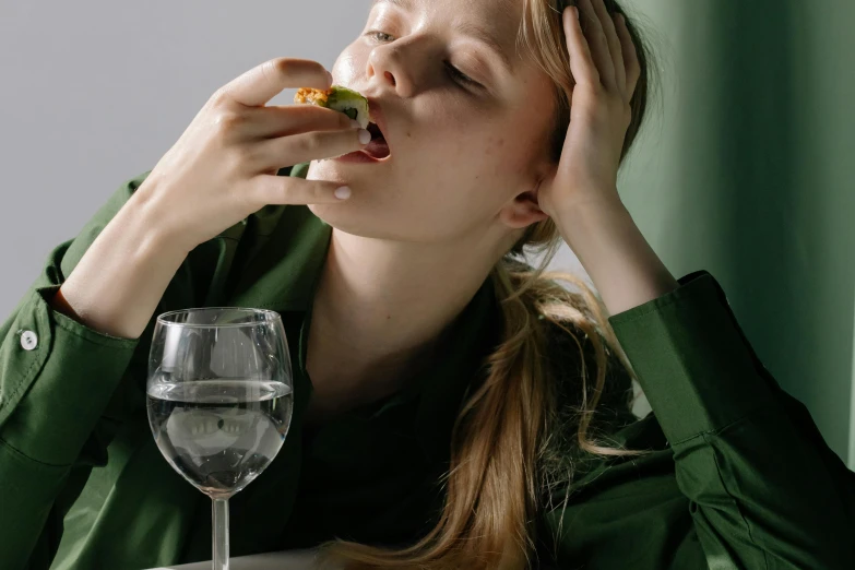 a woman sitting at a table eating a piece of pizza, inspired by Gillis Rombouts, trending on pexels, renaissance, absinthe, tired half closed, with seaweed, john pawson