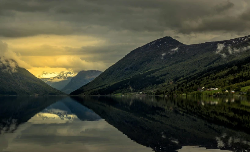 a body of water surrounded by mountains under a cloudy sky, by Harald Giersing, pexels contest winner, hurufiyya, reflections. shady, dramatic lighting - n 9, suntur, multiple stories