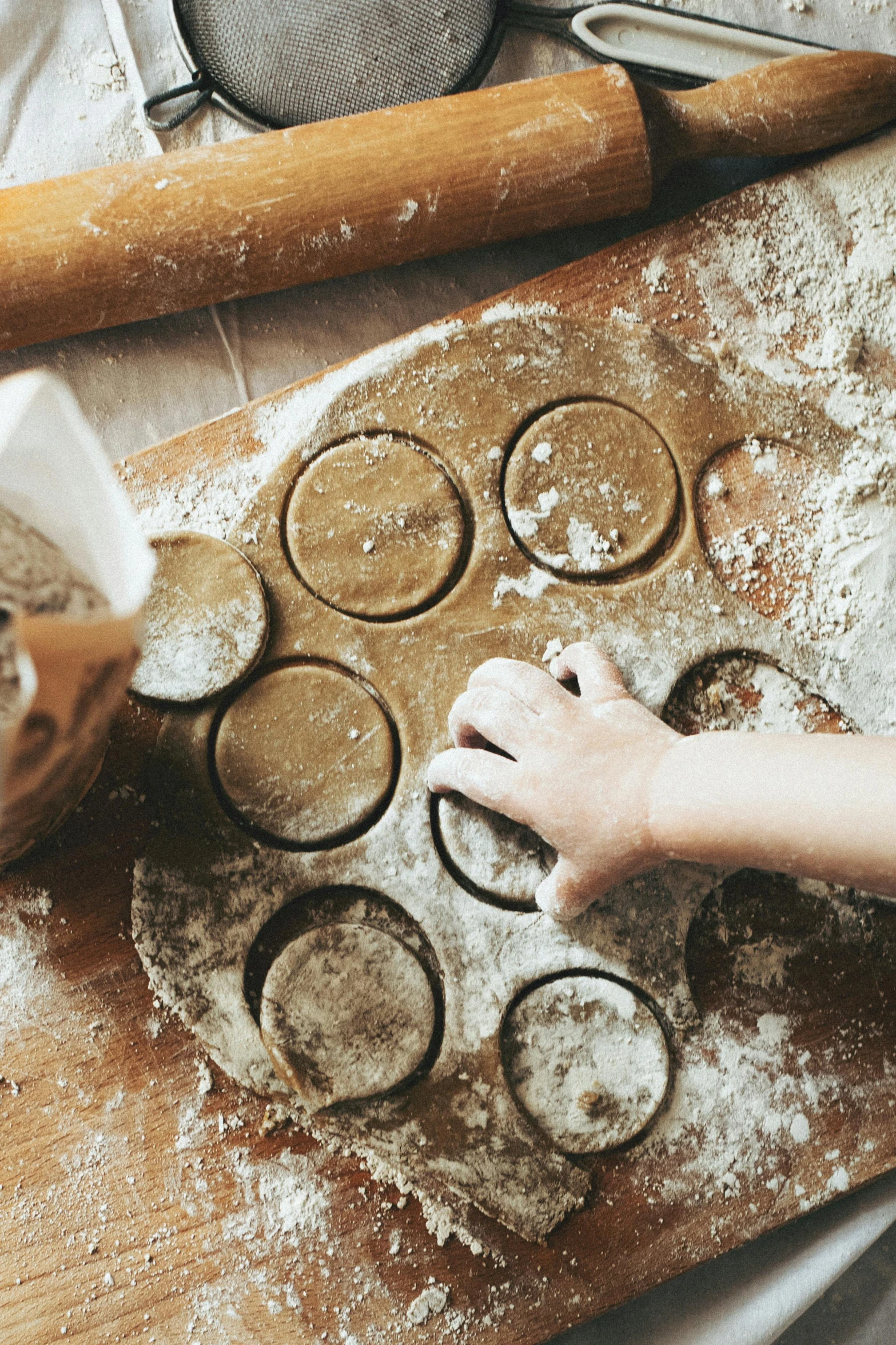 a person rolling out dough on a wooden cutting board, inspired by Li Di, pexels contest winner, process art, children playing with pogs, dark and dusty, promo image, dumplings on a plate