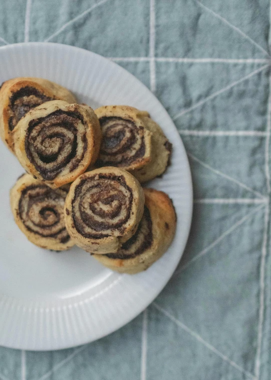 a close up of a plate of food on a table, cookies, marbled swirls, half turned around, grayish