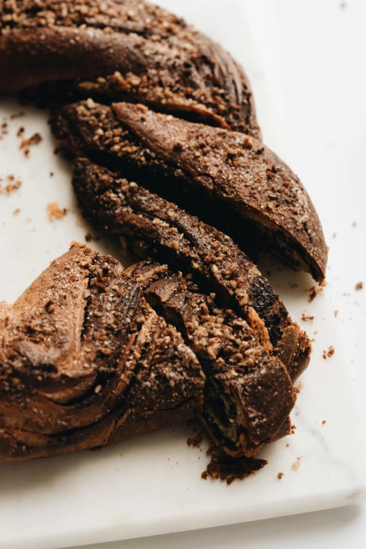 a loaf of chocolate bread with a bite taken out of it, a portrait, trending on pexels, art nouveau, organic rippling spirals, made of tar, side view close up of a gaunt, detailed product image