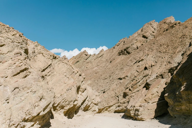 a man riding a surfboard on top of a sandy beach, unsplash, les nabis, geological strata, hollister ranch, gorge in the mountain, profile image