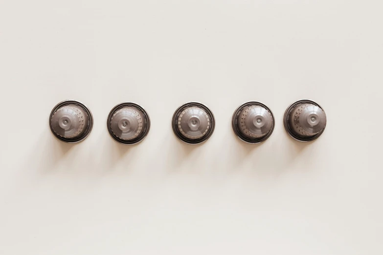 a number of knobs on a white surface, inspired by Louise Bourgeois, trending on pexels, six-pack, on a wall, brown, turrets