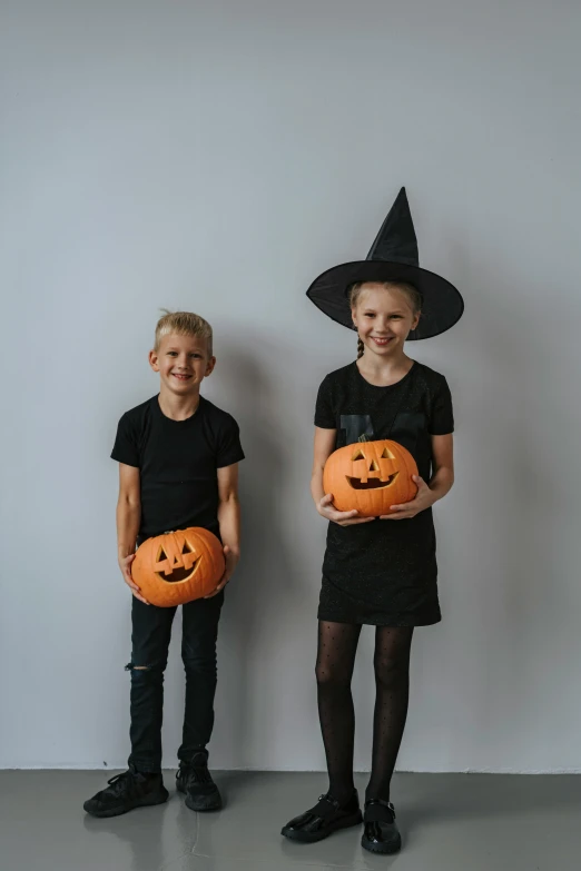 two children in halloween costumes holding pumpkins, pexels contest winner, antipodeans, wearing a black t-shirt, dasha taran, high, profile image