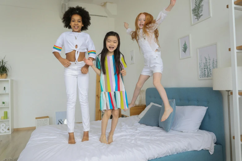 a group of girls jumping on top of a bed, pexels, white trendy clothes, three colors, kids playing, good night