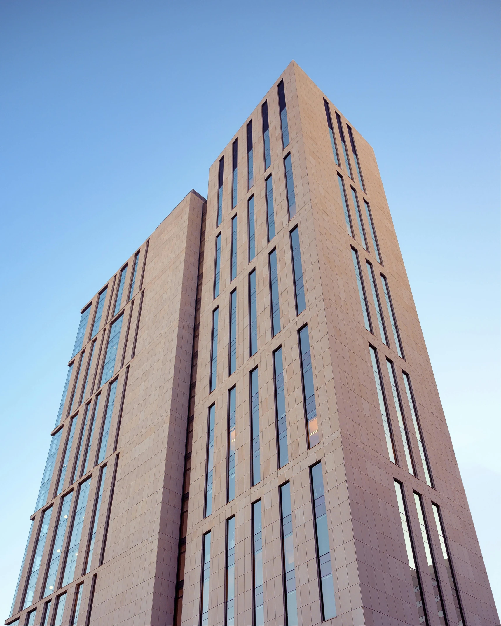 a tall brown building with lots of windows, inspired by David Chipperfield, unsplash, coventry city centre, official screenshot, up-angle view, concrete