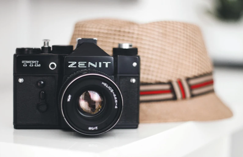 a hat sitting on top of a table next to a camera, pexels contest winner, zenith angle, 8 0 s camera, zoomed in, seventies cinestill
