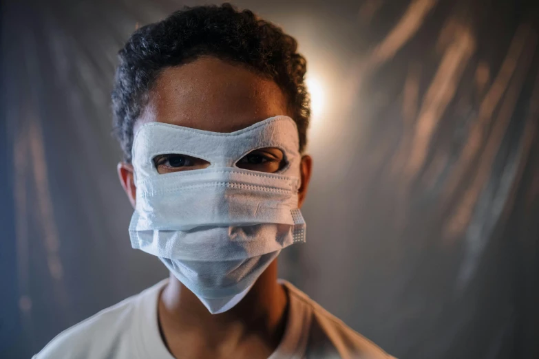 a close up of a person wearing a face mask, by Daniel Lieske, pexels contest winner, black teenage boy, surgeon, halloween, confident looking