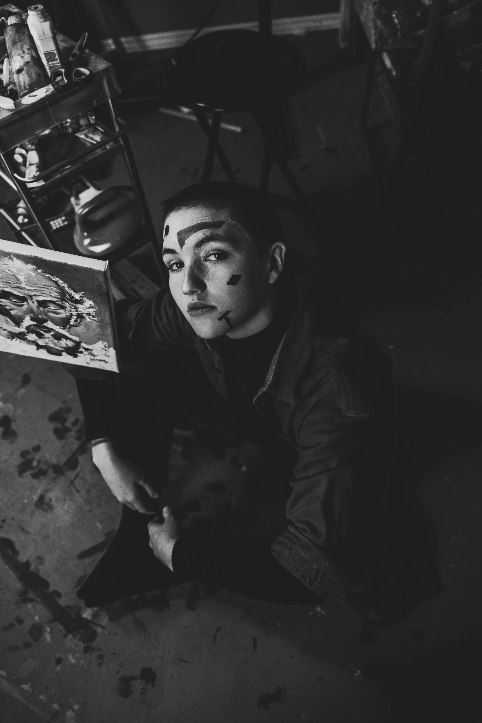 a black and white photo of a man sitting on the floor, a charcoal drawing, inspired by Taro Yamamoto, tumblr, serial art, portrait of florence pugh, mime, warpaint aesthetic, androgynous vampire