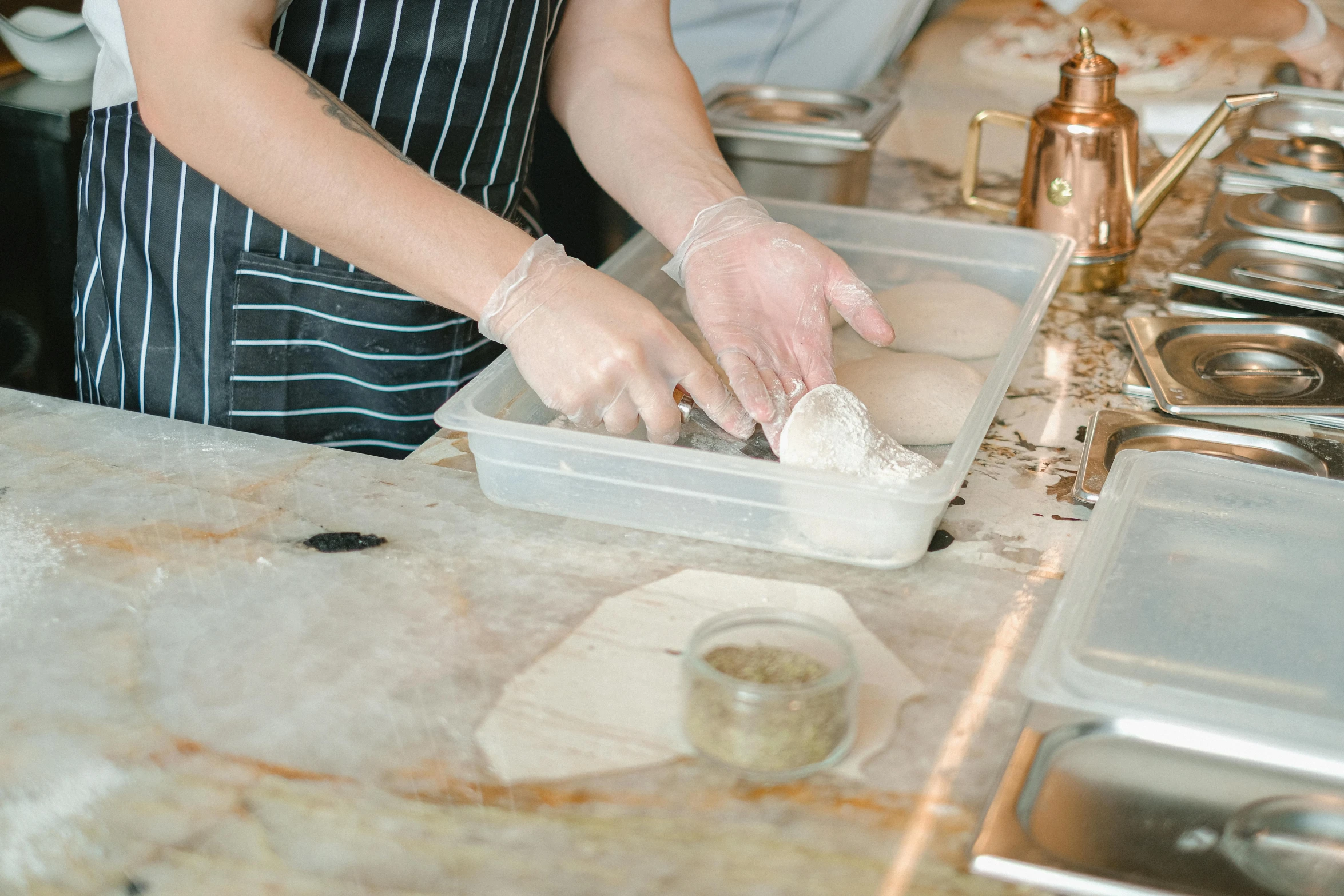 a woman in an apron preparing doughnuts in a kitchen, by Arabella Rankin, unsplash, paper marbling, parchment, in a workshop, thumbnail