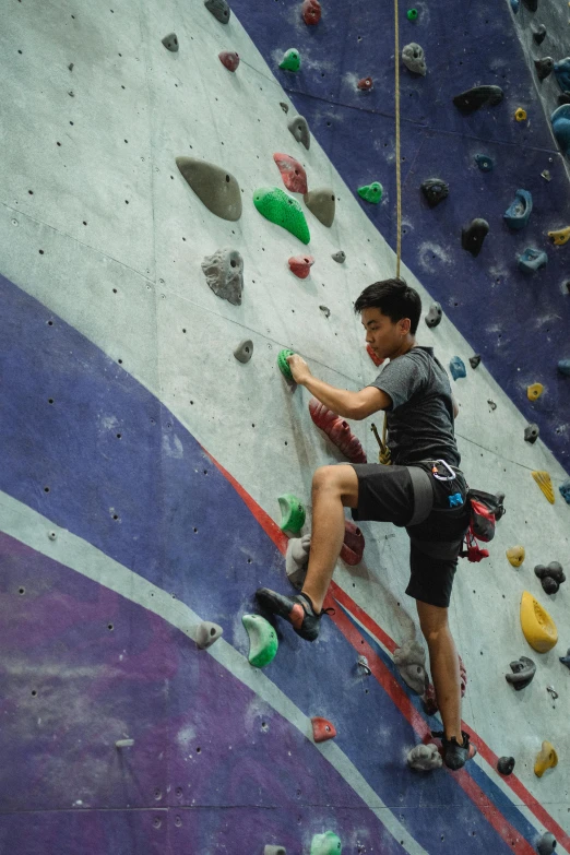 a man is climbing on a rock wall, happening, christopher cao, teenager hangout spot, looking confident, taken in 2 0 2 0