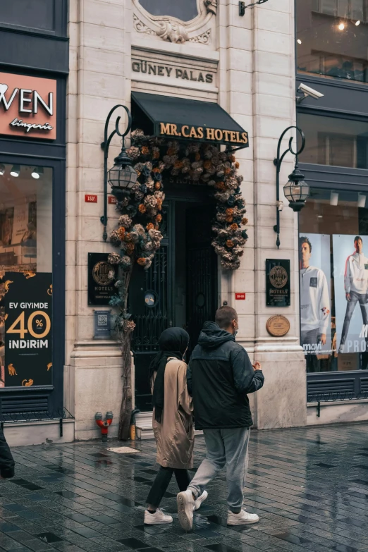 a group of people walking down a street, art nouveau, paris hotel style, exiting store, streetwear, flowers around