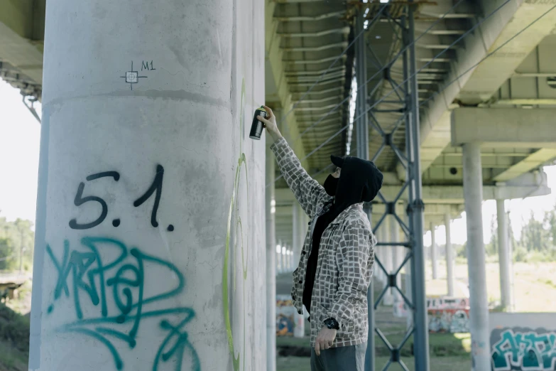 a person standing next to a pole with graffiti on it, graffiti, under bridge, filling the frame, black marker, investigation